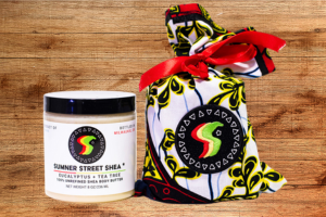 A jar of shea butter next to a decorative bag holding a jar of shea butter.